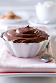 a chocolate dessert is sitting on a pink napkin with a spoon in front of it