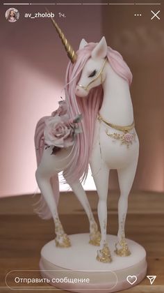 a white and pink unicorn figurine standing on top of a wooden table