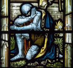 a stained glass window with a knight kneeling down