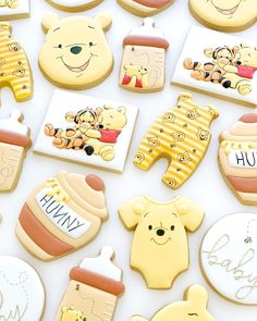 winnie the pooh cookies are arranged on a white surface with baby items around them