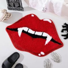 the rug is shaped like a mouth and has teeth on it, along with other accessories