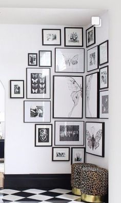 a room with black and white checkered flooring and lots of framed pictures on the wall