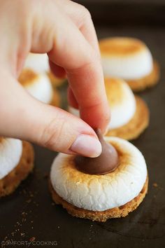 someone is dipping something into some kind of doughnut on top of other small ones