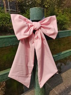 a pink bow tied to a green pole