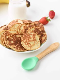 some pancakes on a plate with strawberries and milk