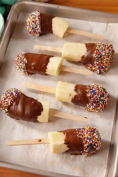 chocolate dipped bananas with sprinkles are on a baking sheet and ready to be eaten