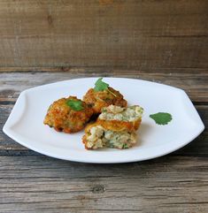 three crab cakes on a white plate with parsley