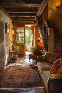 a living room filled with furniture and a fire place next to a wooden flooring wall