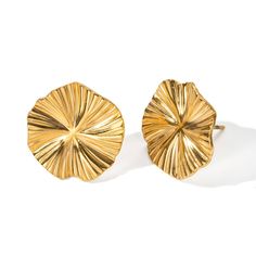 two pairs of gold toned earrings on a white background, one is shaped like a flower