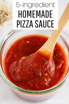 homemade pizza sauce in a glass bowl with a wooden spoon and text overlay that reads homemade pizza sauce