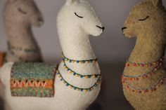 two llamas are standing next to each other with beads on their neck and arms