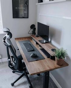 a desk with a monitor, keyboard and mouse on it in front of a window