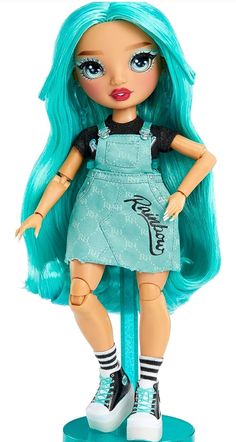 a doll with blue hair is standing on top of a pole and has her hands in her pockets