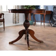 a wooden table sitting on top of a hard wood floor next to two brown chairs