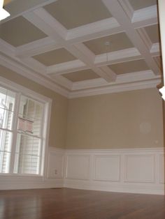 an empty room with hard wood floors and white trim