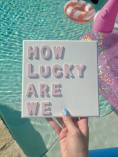 someone holding up a sign that says how lucky are we? in front of a pool