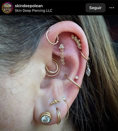 an ear with three different types of piercings on top of it, and one has a diamond in the middle