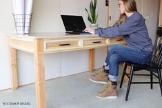 a woman sitting at a desk using a laptop computer