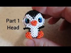 the beaded penguin is being held by someone