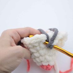 someone is crocheting a sheep with yarn