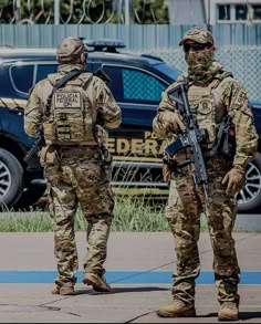 two soldiers are standing in front of a car