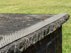 a close up of a stone wall with grass in the background