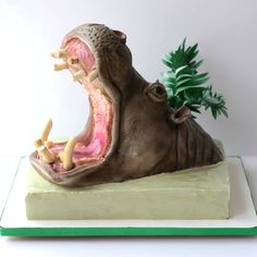 a fake hippopotamus with its mouth open and teeth wide open on a plate