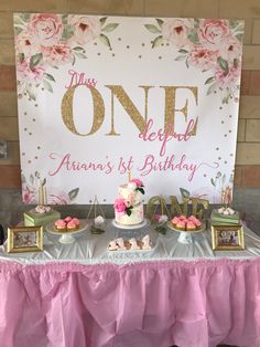 a table topped with cakes and cupcakes next to a sign