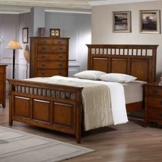 a wooden bed sitting in a bedroom on top of a hard wood floor next to a night stand