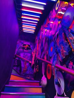 the inside of a brightly lit room with neon lights and skateboards hanging from the ceiling