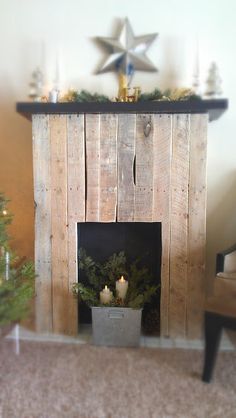 a fireplace with candles and christmas decorations on top