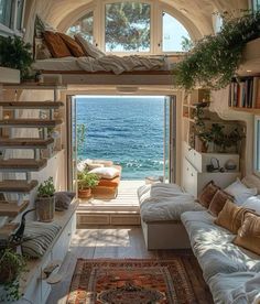 a living room filled with lots of furniture next to an open window overlooking the ocean