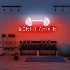 a neon sign that says work harder in front of a gym with dumbs and exercise balls