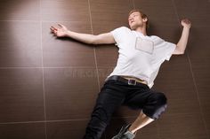 a young man laying on the floor with his arms outstretched and eyes closed stock photos