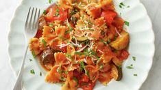 a white plate topped with pasta and vegetables