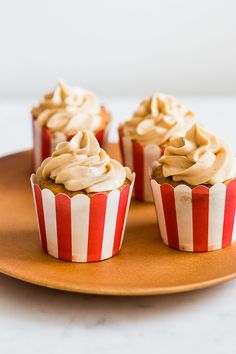 three cupcakes with frosting on a plate