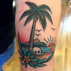 a man's arm with a palm tree and skull on it