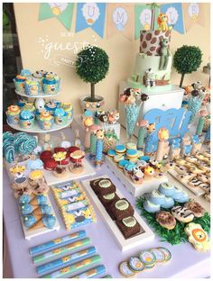 a baby shower party with giraffes and cupcakes on the table