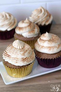 cupcakes with white frosting and cinnamon sprinkles on a plate