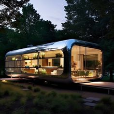 a glass house in the middle of a park at night with lights on it's sides