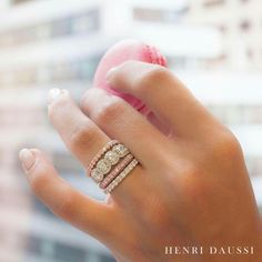 a woman's hand holding an apple and two stacking rings on her fingers