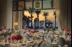 a dining room with tables and chairs set up for a formal dinner overlooking the ocean