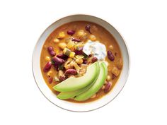 a white bowl filled with beans, avocado and sour cream on top of it