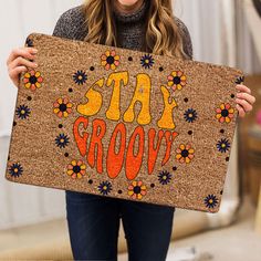 a woman holding up a sign that says eat grooy with flowers on it