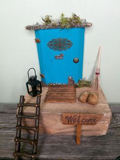 a wooden table topped with a potted plant next to a blue door