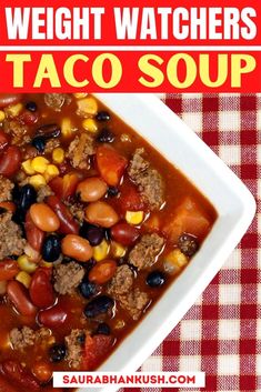 a white bowl filled with taco soup on top of a red and white checkered table cloth