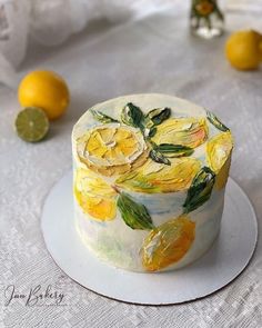 there is a cake decorated with yellow flowers on the plate and lemons in the background