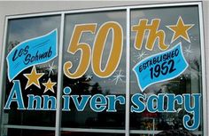 an image of a store window that has 50th anniversary signs on the front and side