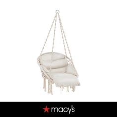 a white hanging chair with fringes on it