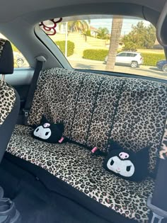 the interior of a car with leopard print and black cat pillows on it's seat covers